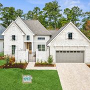 A stunning modern home with white brick and a pitched roof.