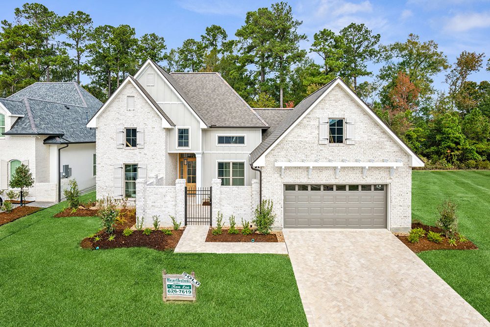 A stunning modern home with white brick and a pitched roof.