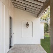 A black-framed glass door suggests a transition from the exterior to the interior space, blending classic and modern design elements.