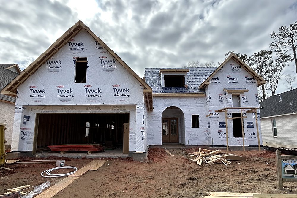 The arched entryway hints at the architectural details planned for the finished home.